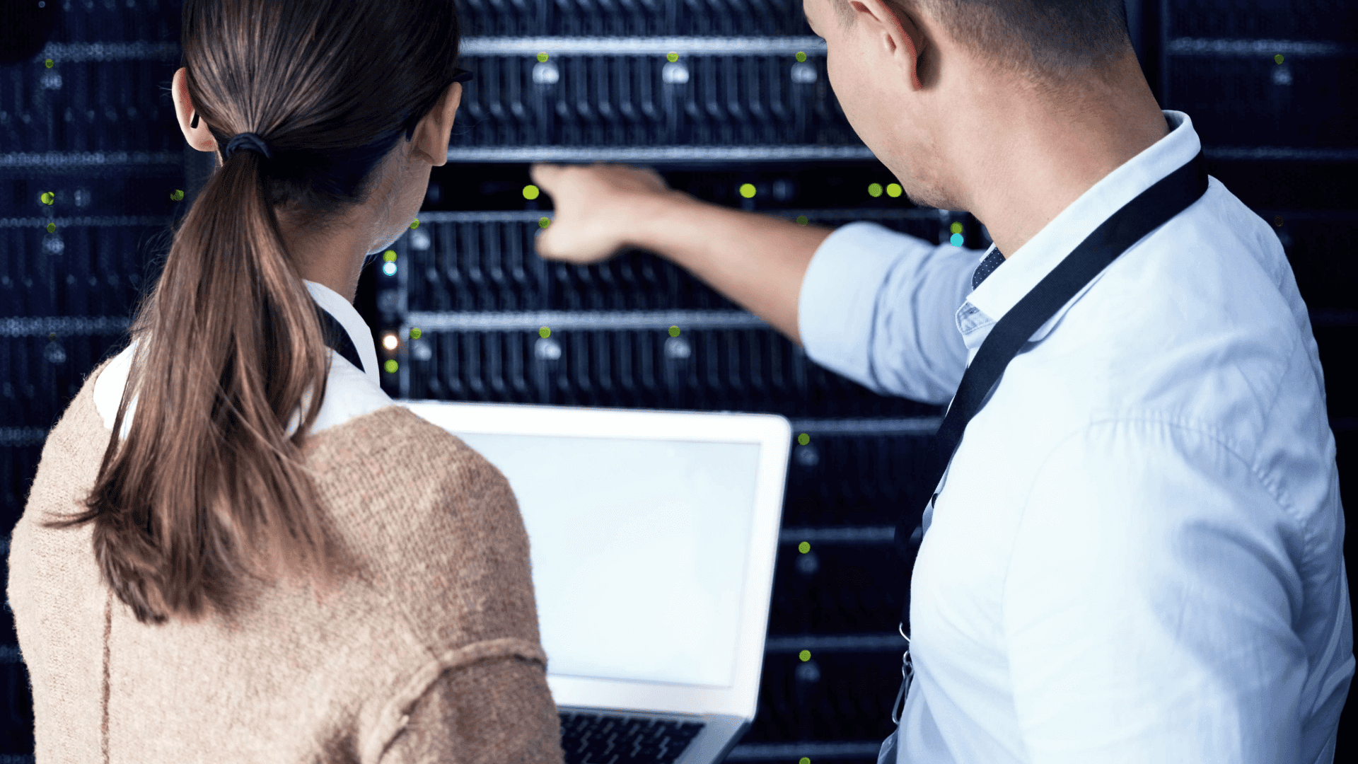 two technicians examining a server rack in an IT room